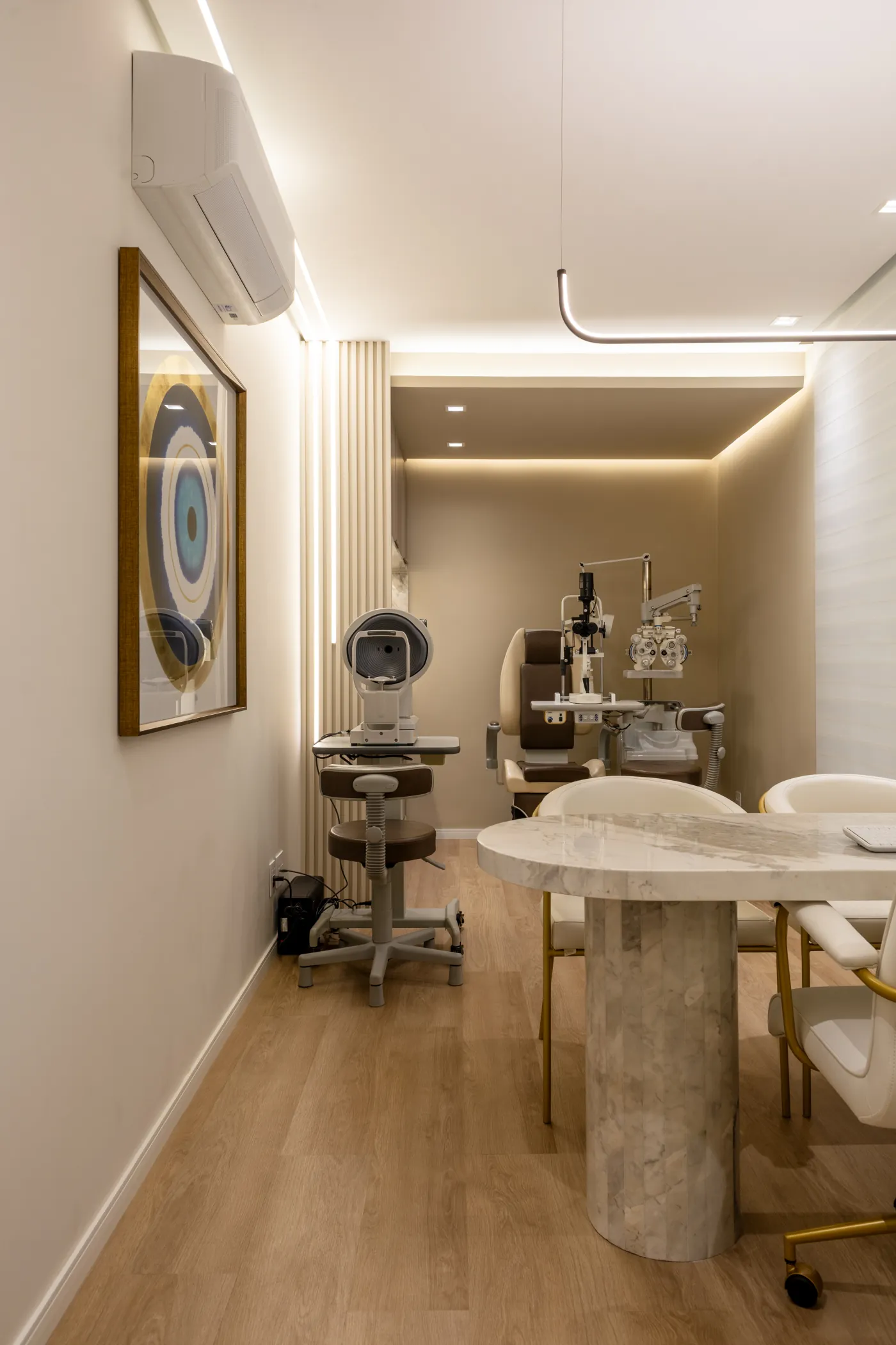 Consultório de oftalmologia com equipamentos de exame e mesa de mármore